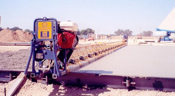 Concrete screed riding on steel flatwork forms